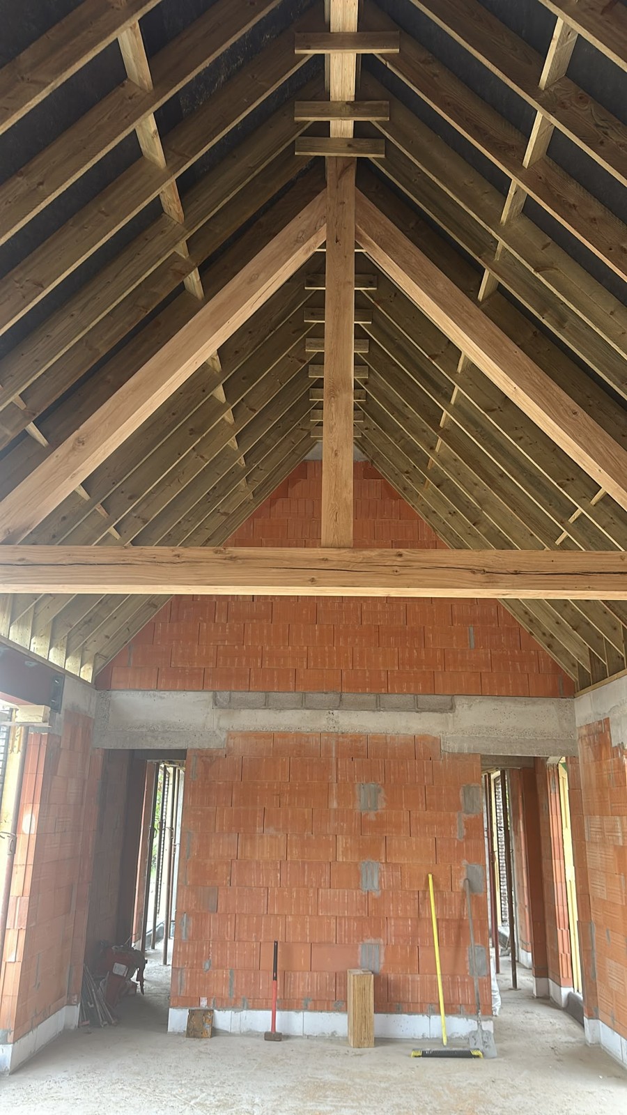 Houten dakstructuur en binnenruimte van het bestaande bijgebouw tijdens de volledige restauratie