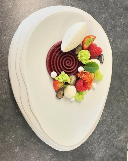 Verfijnd borddessert van Keshia met rode spiraal, fruit en witte chocolade